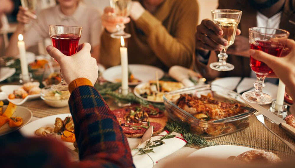 Guests at a dinner table lifting glasses for a toast